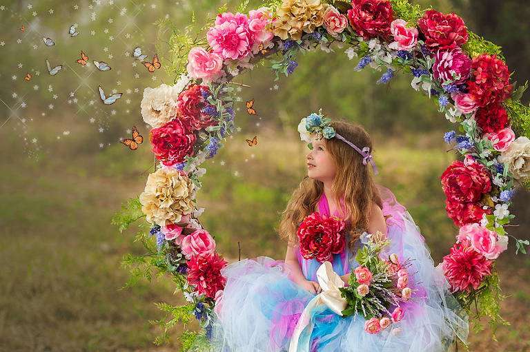 girl on floral swing with butterflies